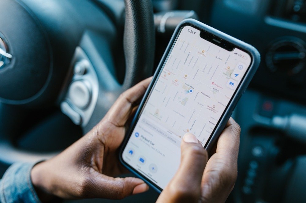 A person in a vehicle following a delivery's live location on a map on their phone